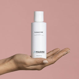 a model holding the cleanser bottle in the palm of their hand