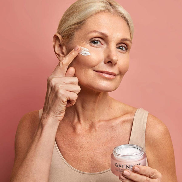 A model applying Gatineau Collagene Expert Ceramide Smoothing Cream to her face.