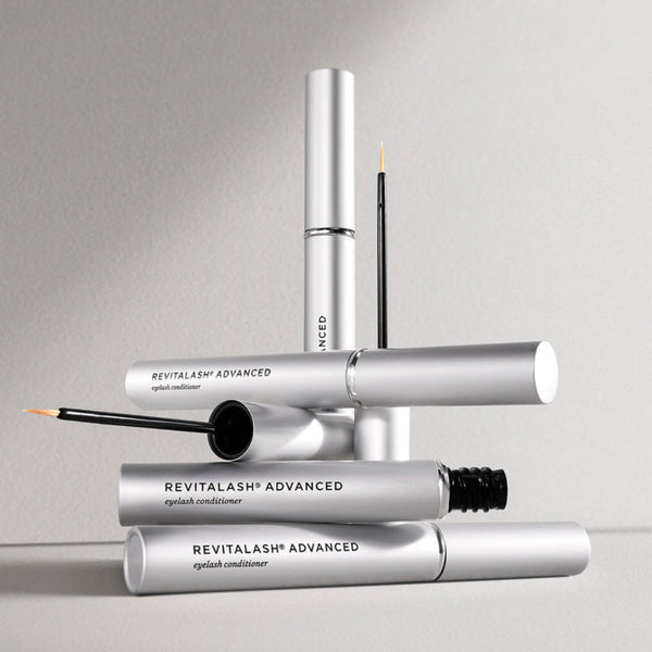 four Revitalash Advanced Eyelash Conditioner placed on top of each other