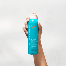 Moroccanoil Dry Texture Spray can being held to the air