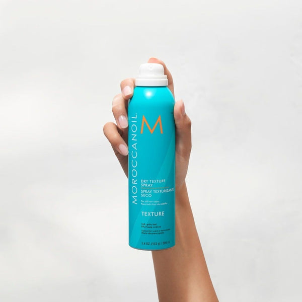 Moroccanoil Dry Texture Spray can being held to the air