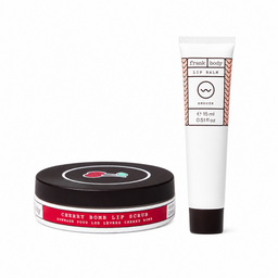 A Frank Body lip balm and cherry bomb lip scrub set on a white background. The set includes a white squeeze tube of lip balm with a black cap and a black round jar of lip scrub with a red label.