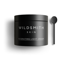 Black jar of Wildsmith Skin hydrating light cream with a spoon on a white background