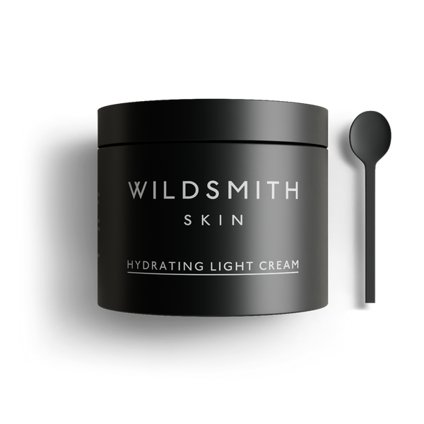 Black jar of Wildsmith Skin hydrating light cream with a spoon on a white background