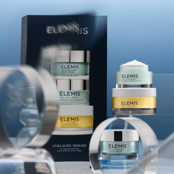 Elemis skincare products on a reflective surface with a blue gradient background