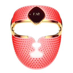 A red silicone facial massage mask with gold trim and a central dark brown plaque featuring the gold 'FAQ' logo, shown on a solid white background.