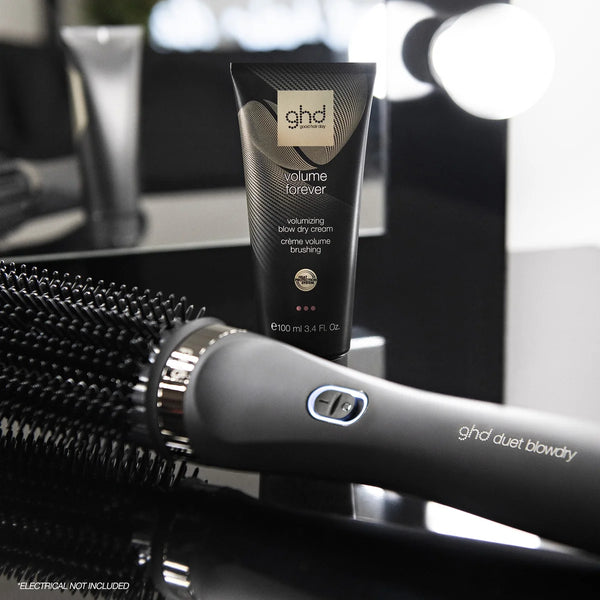 ghd volume forever cream tube with ghd duet blowdry on a reflective surface