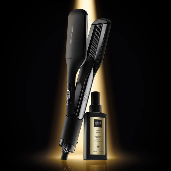 Hair straightener and bottle with 'ghd' branding on a dark background