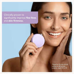 A woman with clear skin holds a small round purple skincare device against her cheek, with text on a light blue background stating it is clinically proven to improve fine lines and skin firmness.