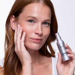 a model holding a bottle of the complex to their face