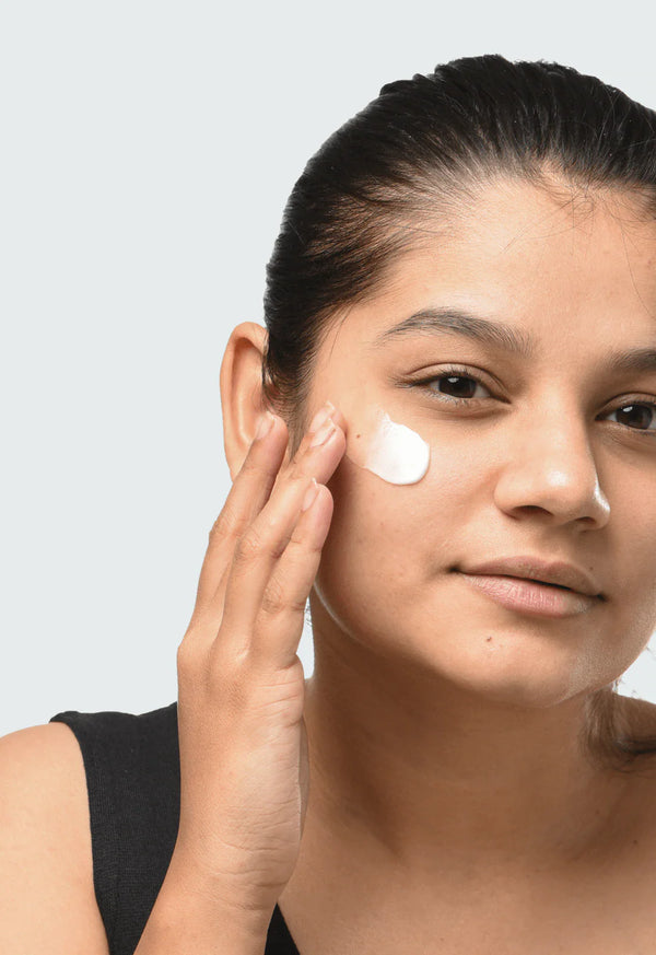 a women applying Minimalist Marula Oil 05% Moisturizer to her face
