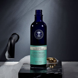 Neal's Yard Remedies Aromatic Foaming Bath bottle on a black marble top