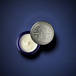 a birds eye view of a Neal's Yard Remedies Frankincense Intense Lift Eye Cream tub with an open lid