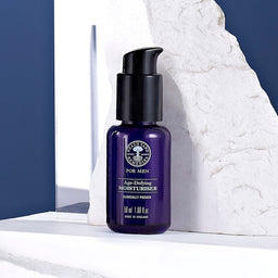 Neal's Yard Remedies Purifying Face Wash bottle in front of a chipped stone wall