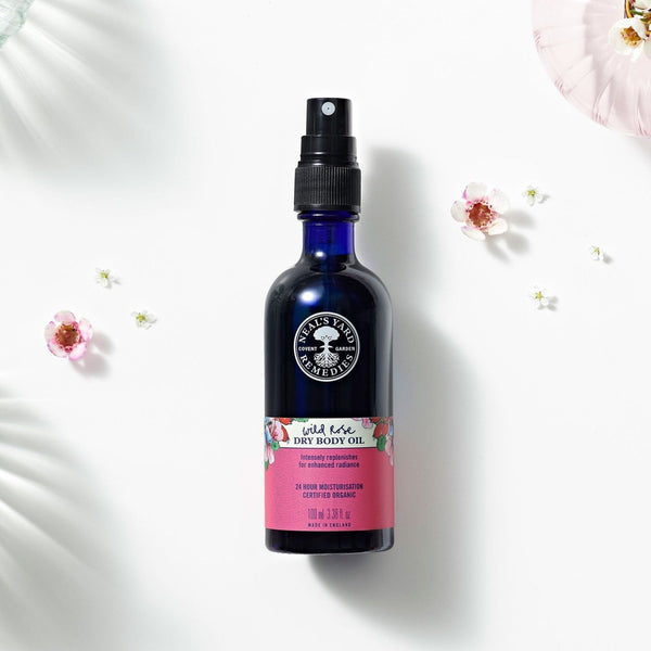 Neal's Yard Remedies Wild Rose Dry Oil next to a range of small flowers