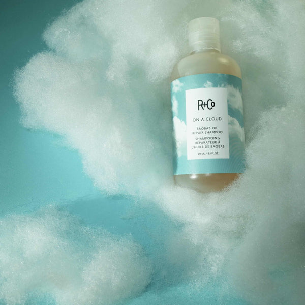 R+Co On A Cloud Repair Shampoo floating on a cloud
