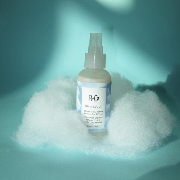 R+Co ON A CLOUD Repair Splash on Style bottle floating on a cloud