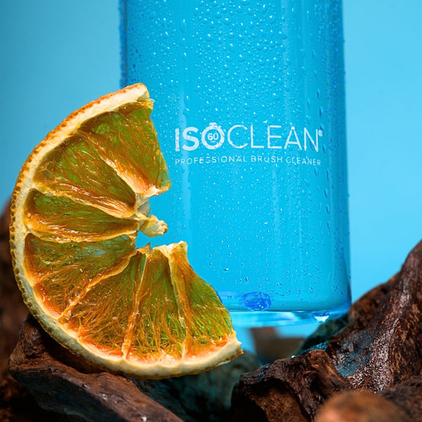 Blue bottle labeled 'ISO CLEAN' with a dried orange slice on a natural background