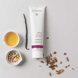 Dr Hauschka Conditioner tube next to its raw ingredients
