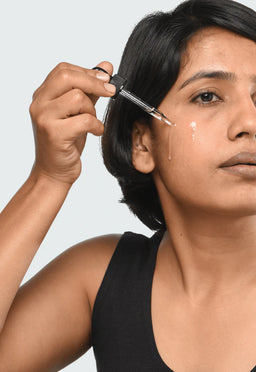 a women applying Minimalist Squalane 100% to her cheek