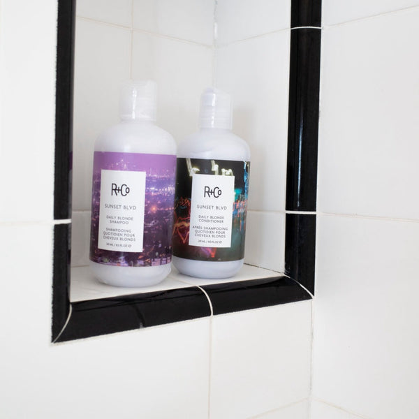 two bottles of R+Co Sunset Blvd in a shower setting