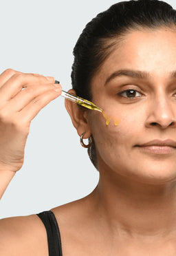 a women applying Minimalist Tranexamic 03% to her cheek
