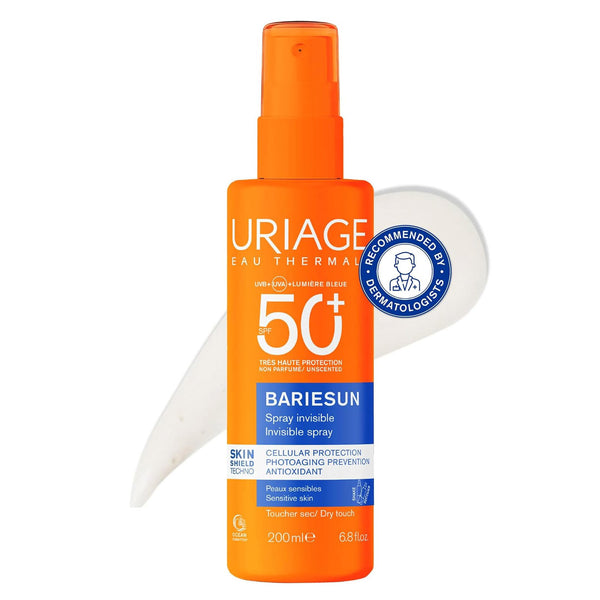 A bottle of Uriage Bariesun 50+ Invisible Spray sunscreen on a white background, featuring an orange spray bottle with blue and white text, a white applicator wand, and a blue dermatology recommendation badge.