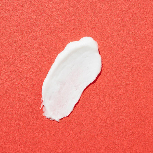 COSRX Salicylic Acid Daily Gentle Cleanser cream poured onto a red background
