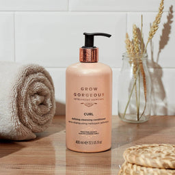 Grow Gorgeous Curl Defining Cleansing Conditioner on a bathroom countertop 