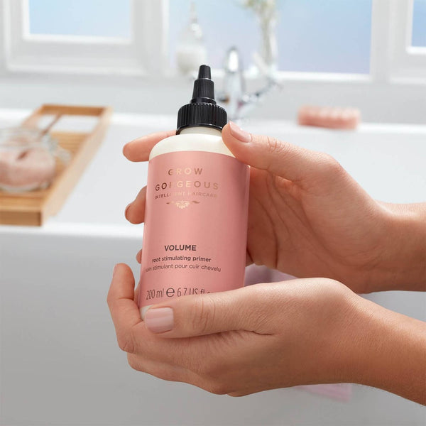  bottle of Grow Gorgeous Volume Root Stimulating Primer held in a hand