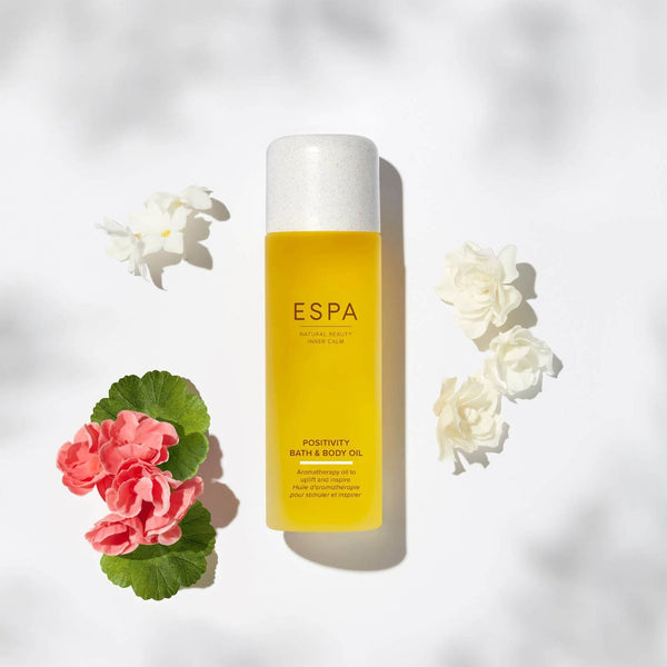 ESPA Positivity Bath & Body Oil surrounded by its natural ingredients 