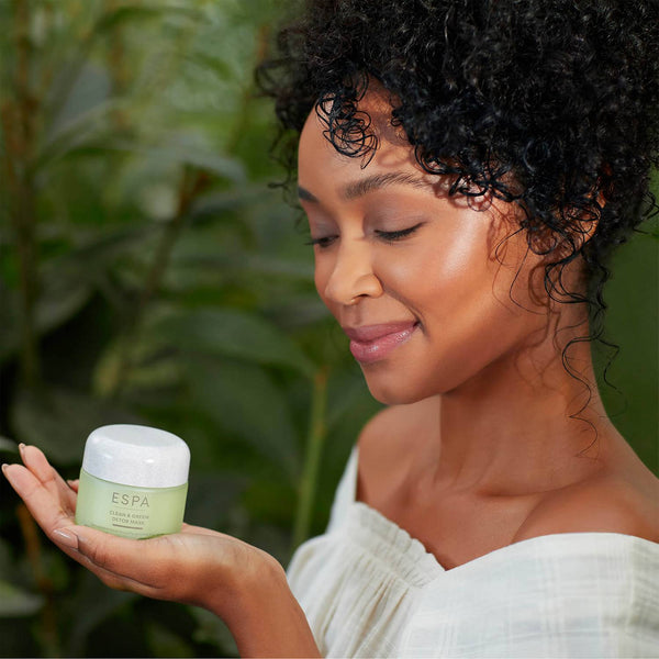 a women holding a jar of ESPA Clean & Green Detox Mask in her hand