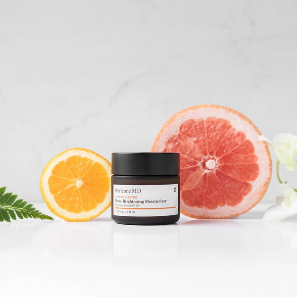 Perricone MD Vitamin C Ester Photo-Brightening Moisturizer tub with slices of oranges behind it