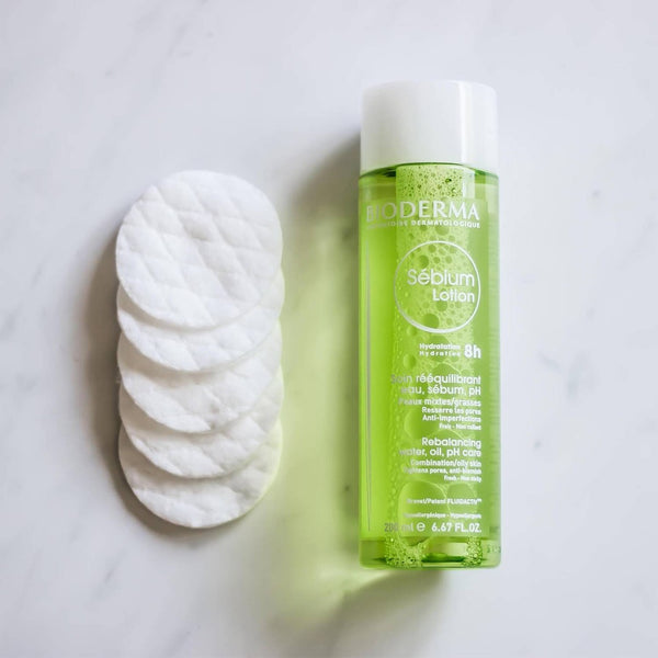 Bioderma Sébium Clarifying Lotion Oily to Combination Skin  with cotton pads set next to the bottle
