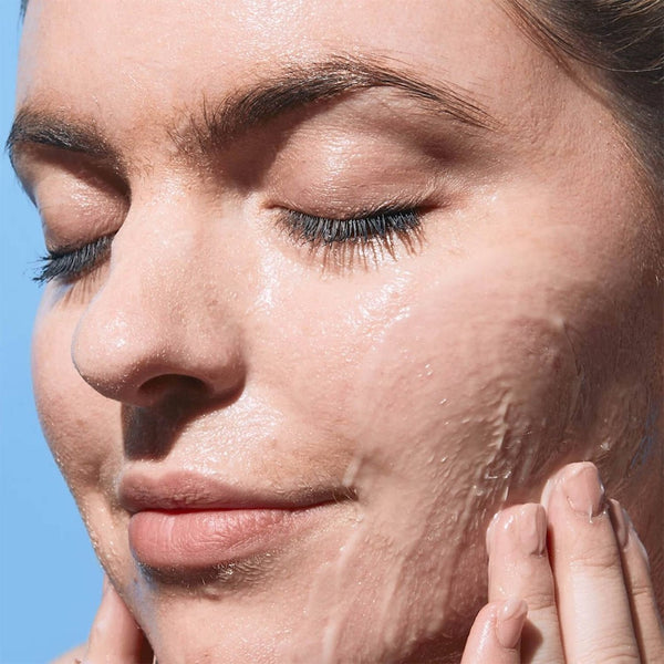 women applying cleanser to her face