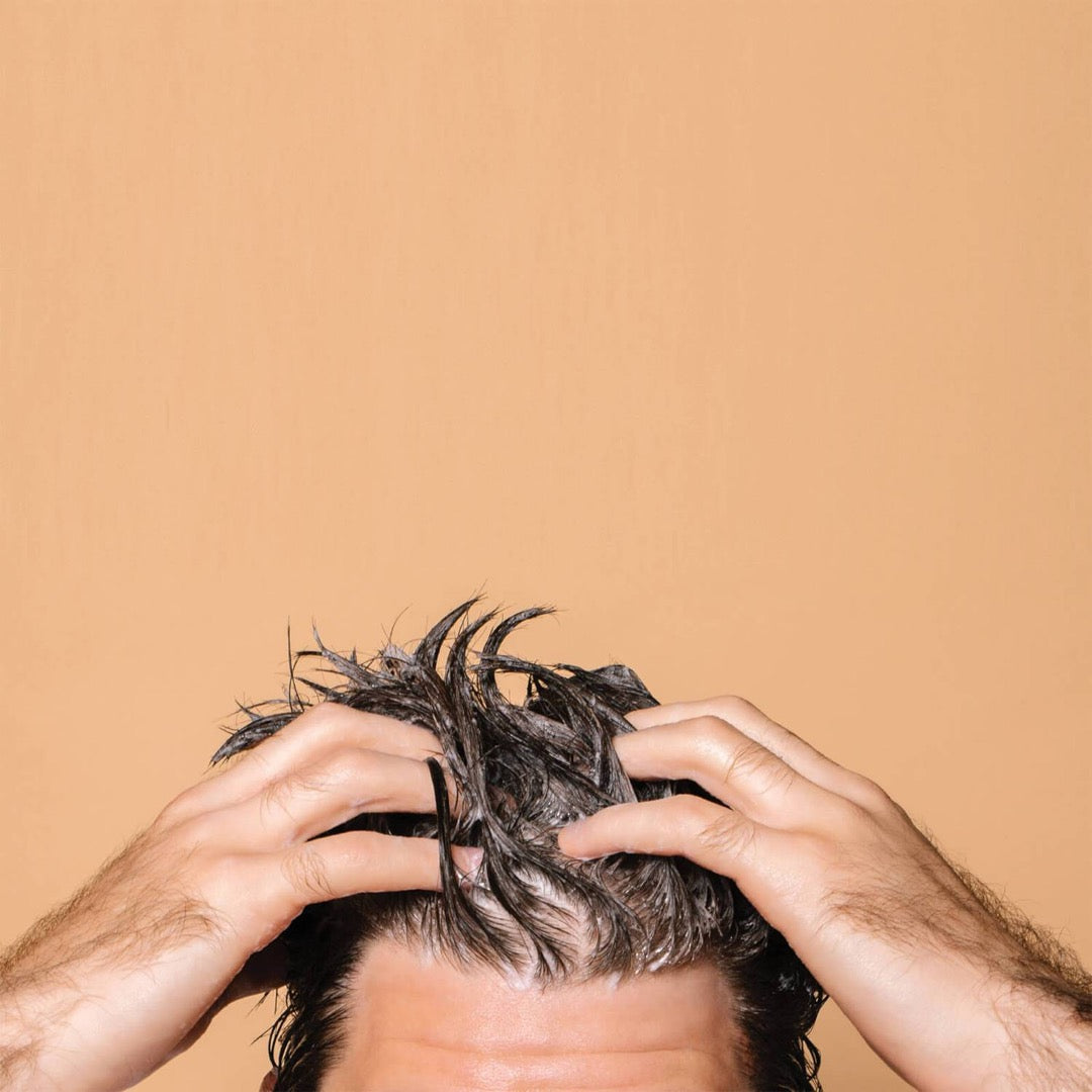 model applying the shampoo to their hair