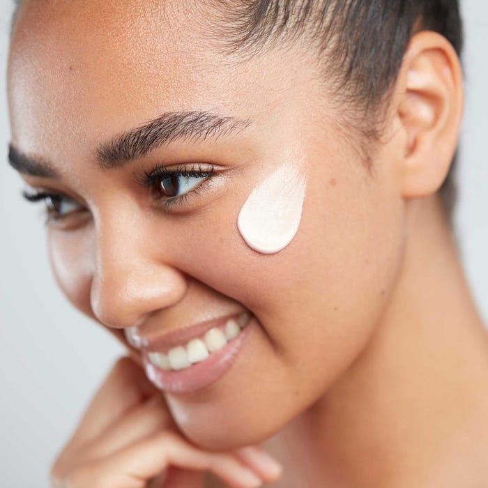 a women with moisturiser on her cheek