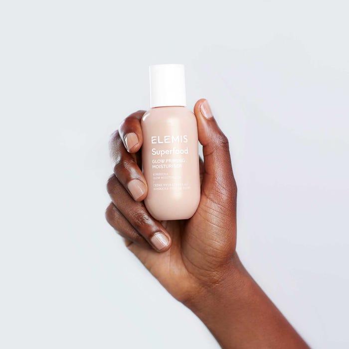 Elemis Superfood Glow Priming Moisturiser held in the palm of a hand