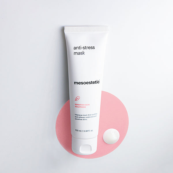 A tube of mesoestetic Anti-Stress Mask on a pink circle and dot of the cream
