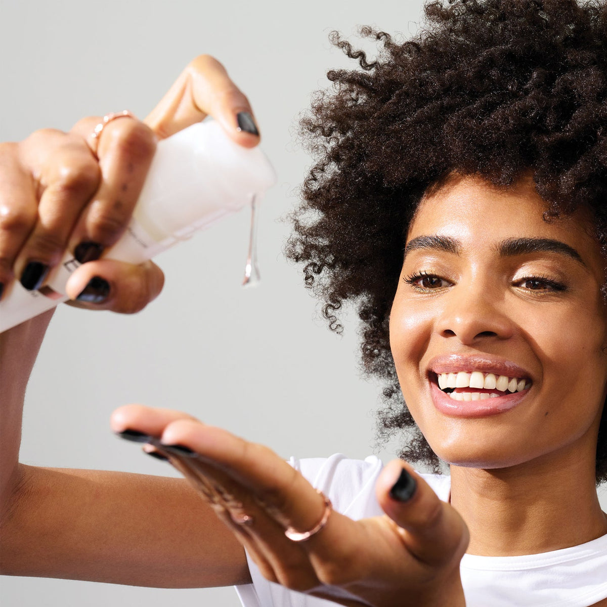 a women applying Olaplex No.9 Bond Protector Nourishing Hair Serum to her hand