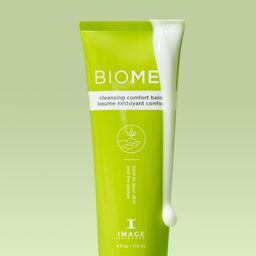 Image Skincare BIOME+ Cleansing Comfort Balm with the cream dropping pouring down the side of the tube