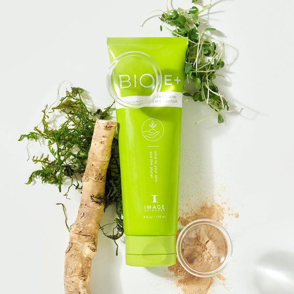 A Image Skincare BIOME+ Cleansing Comfort Balm tube with raw ingredients placed around the tube