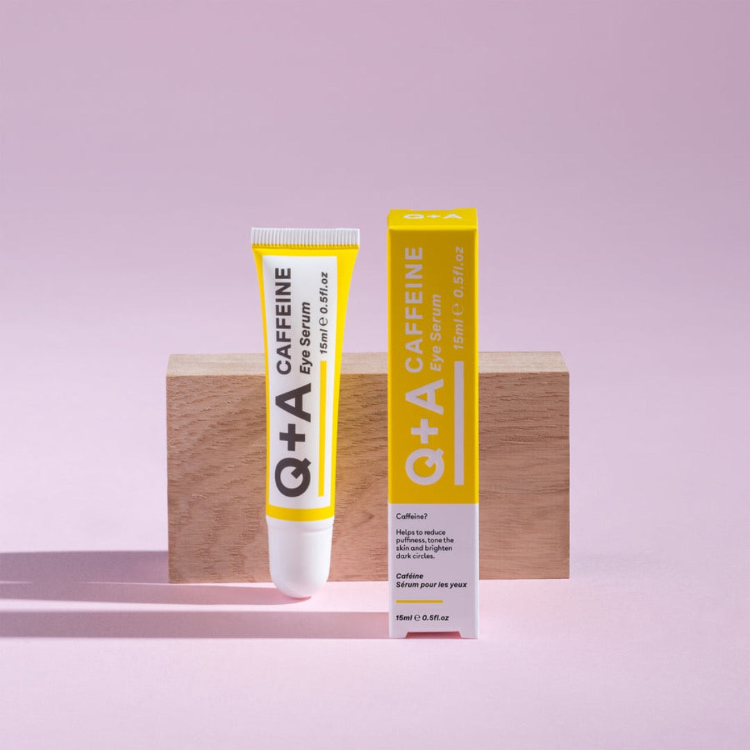 Q+A Caffeine Eye Serum 15ml tube in front of a wooden block