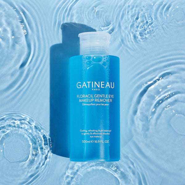 a bottle of Gatineau Floracil Eye Makeup Remover laying in a puddle shallow water