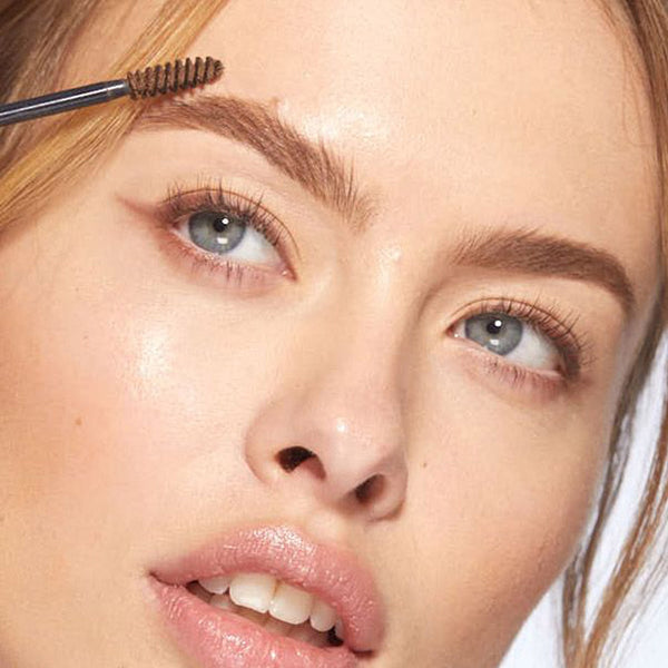 A closeup of a women applying HD Brows Brow Colourfix