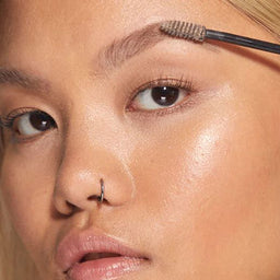 A closeup of a women applying HD Brows Brow Colourfix