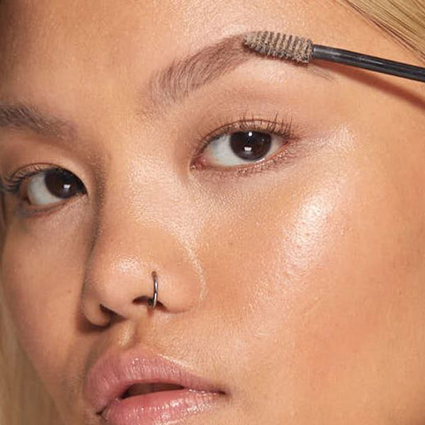 A closeup of a women applying HD Brows Brow Colourfix