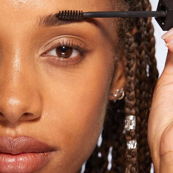 A closeup of a women applying HD Brows Brow Colourfix