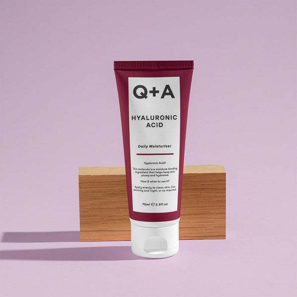 Q+A Hyaluronic Acid Moisturiser in front of a wooden block