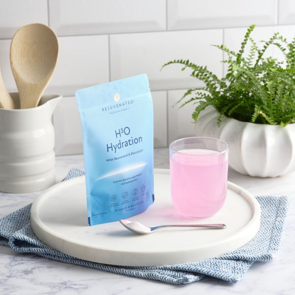  a cup of Rejuvenated H3O Hydration next to its packaging in a kitchen setting